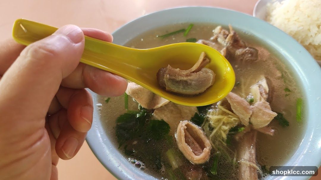 Close-up of a bowl of soup with meat and a spoon