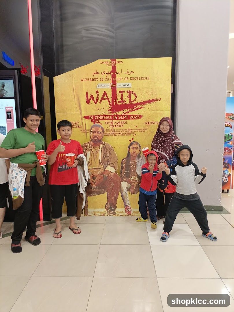 Family Poses in Front of Movie Poster
