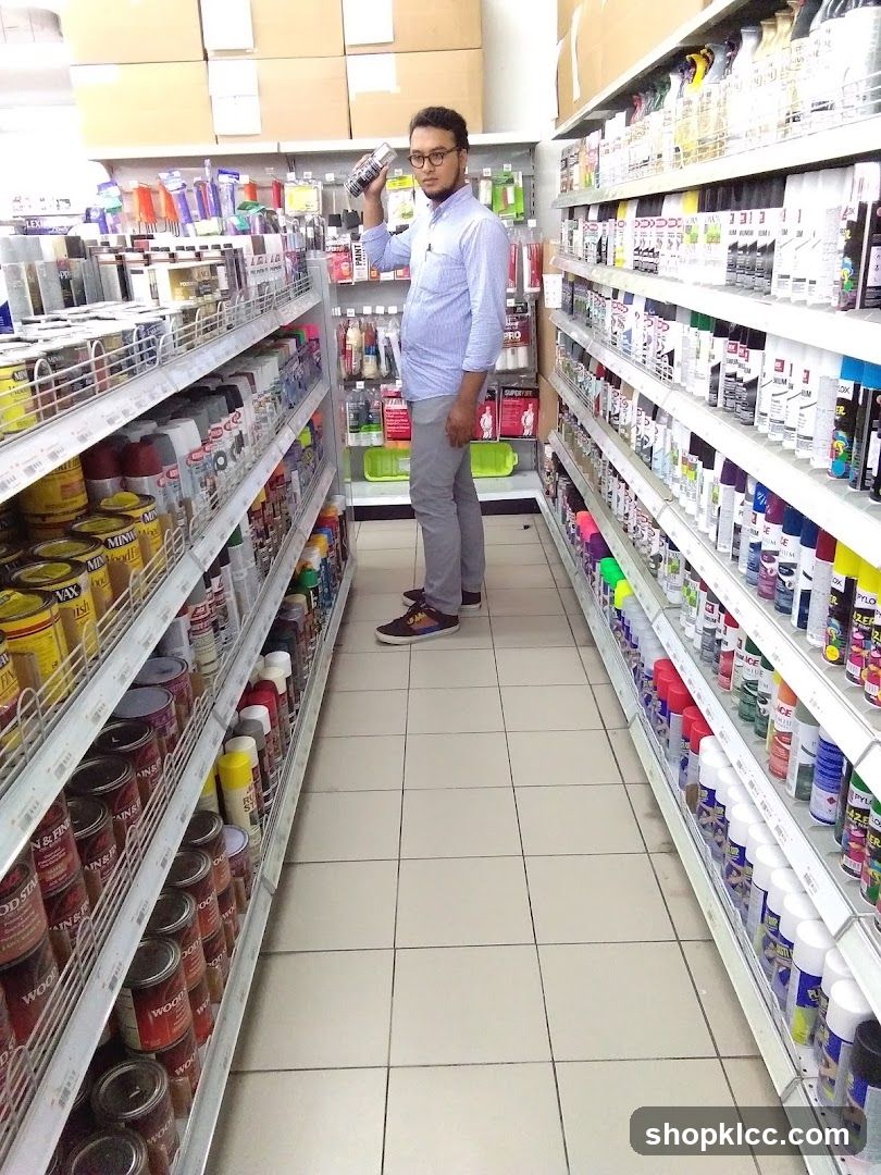 Man holding a spray can in an aisle of a store