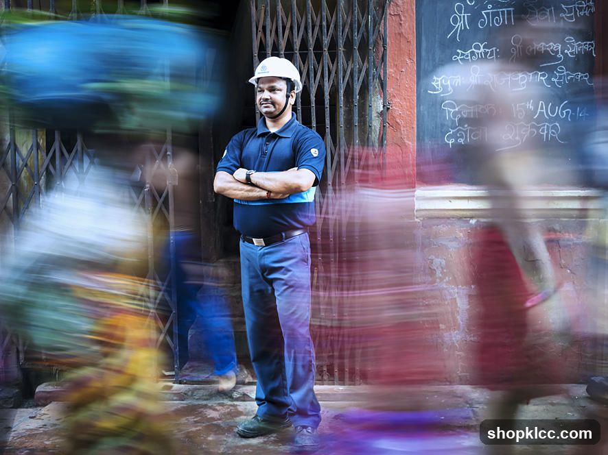 Man in Hard Hat Standing in Front of a Grated Entrance