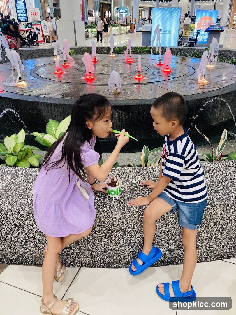 Children eating ice cream by a fountain