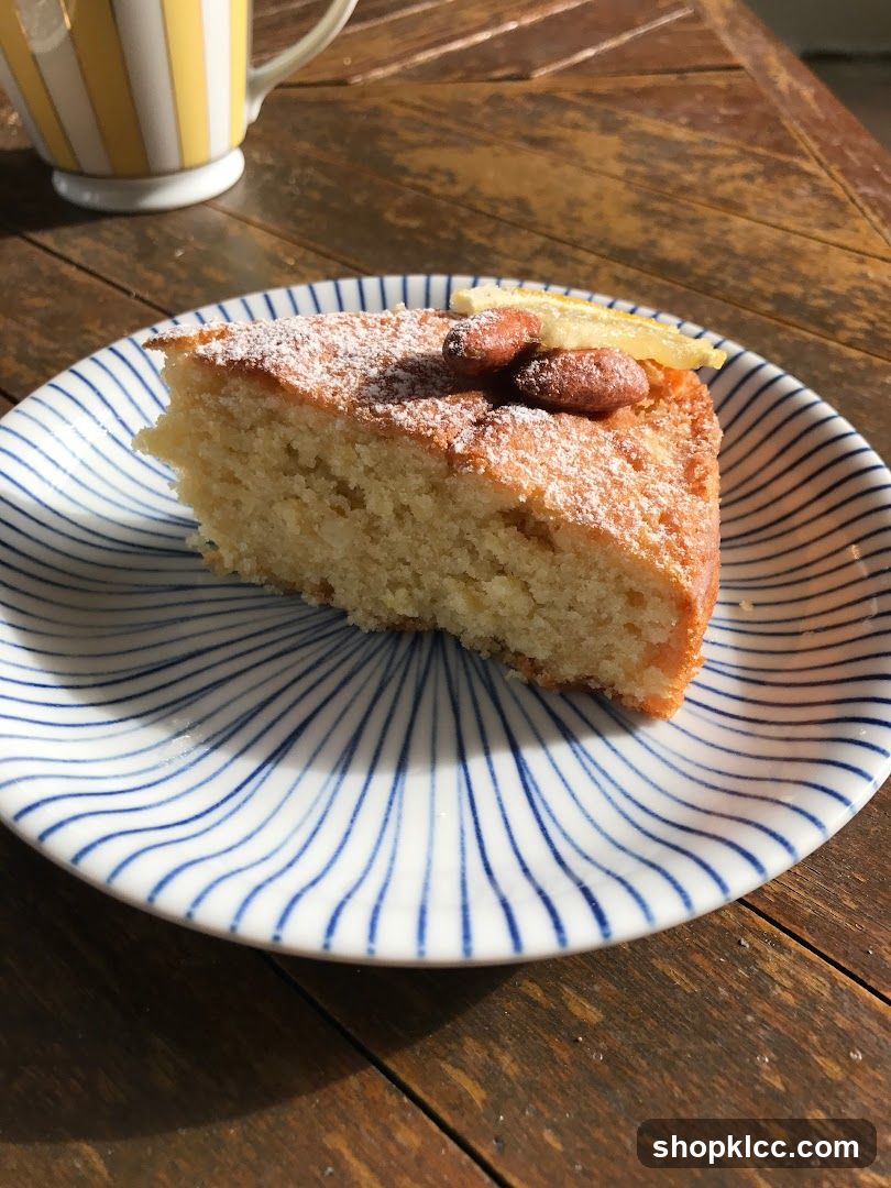 Slice of cake with almonds and lemon on a plate