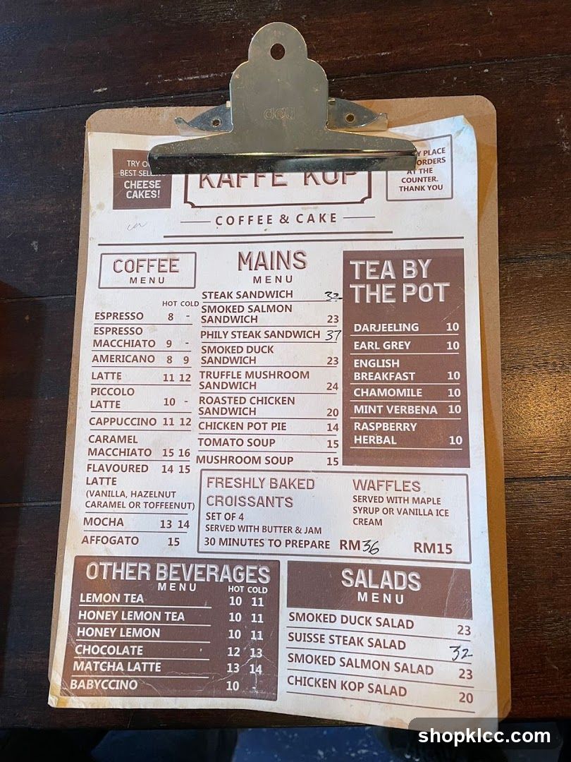 A menu board with sections for Coffee, Mains, Tea by the Pot, Other Beverages, and Salads.