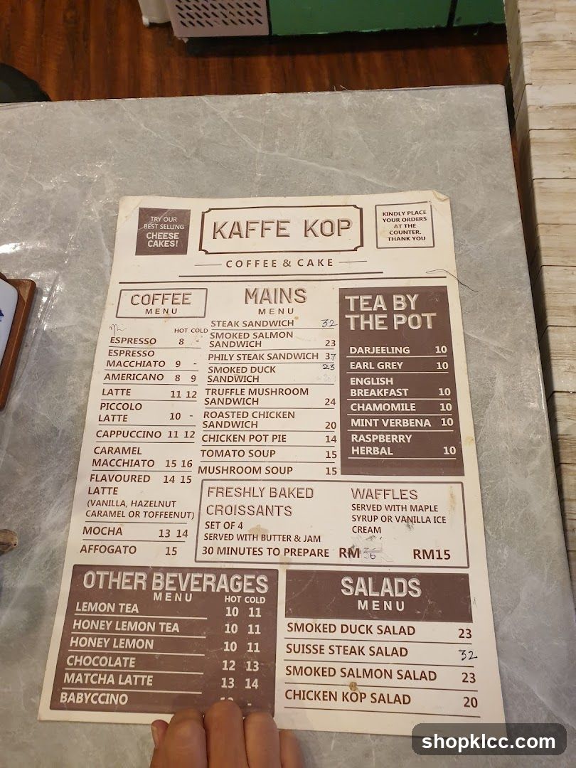 A menu for Kaffe Kop, featuring coffee, mains, tea, other beverages, and salads.