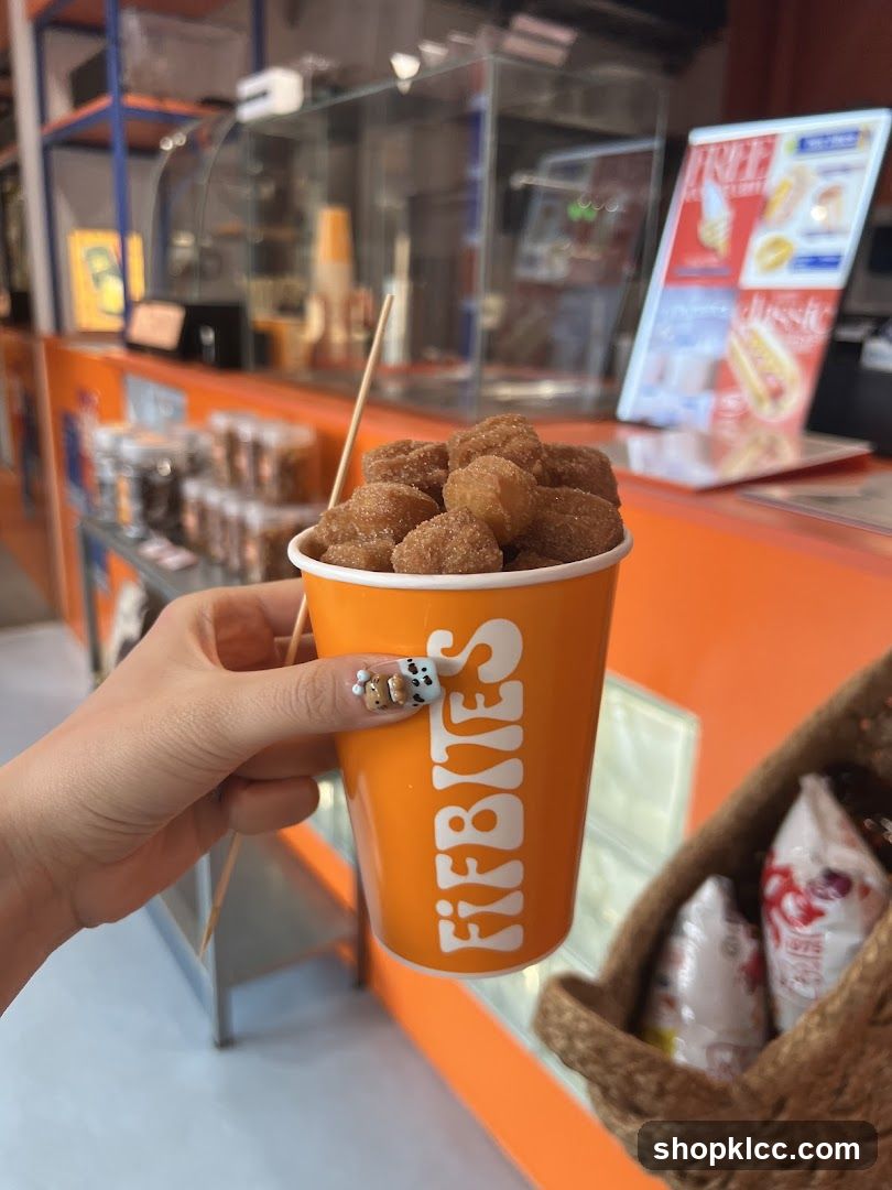 Hand holding a cup of mini donuts