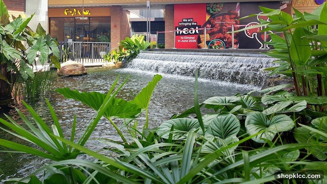 Outdoor seating area with a waterfall and lush greenery