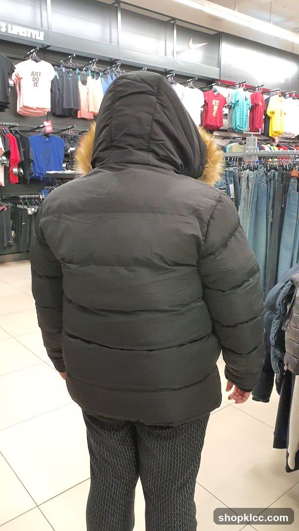 Person wearing a puffer jacket in a clothing store