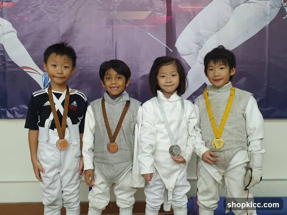 Four Children in Fencing Gear with Medals
