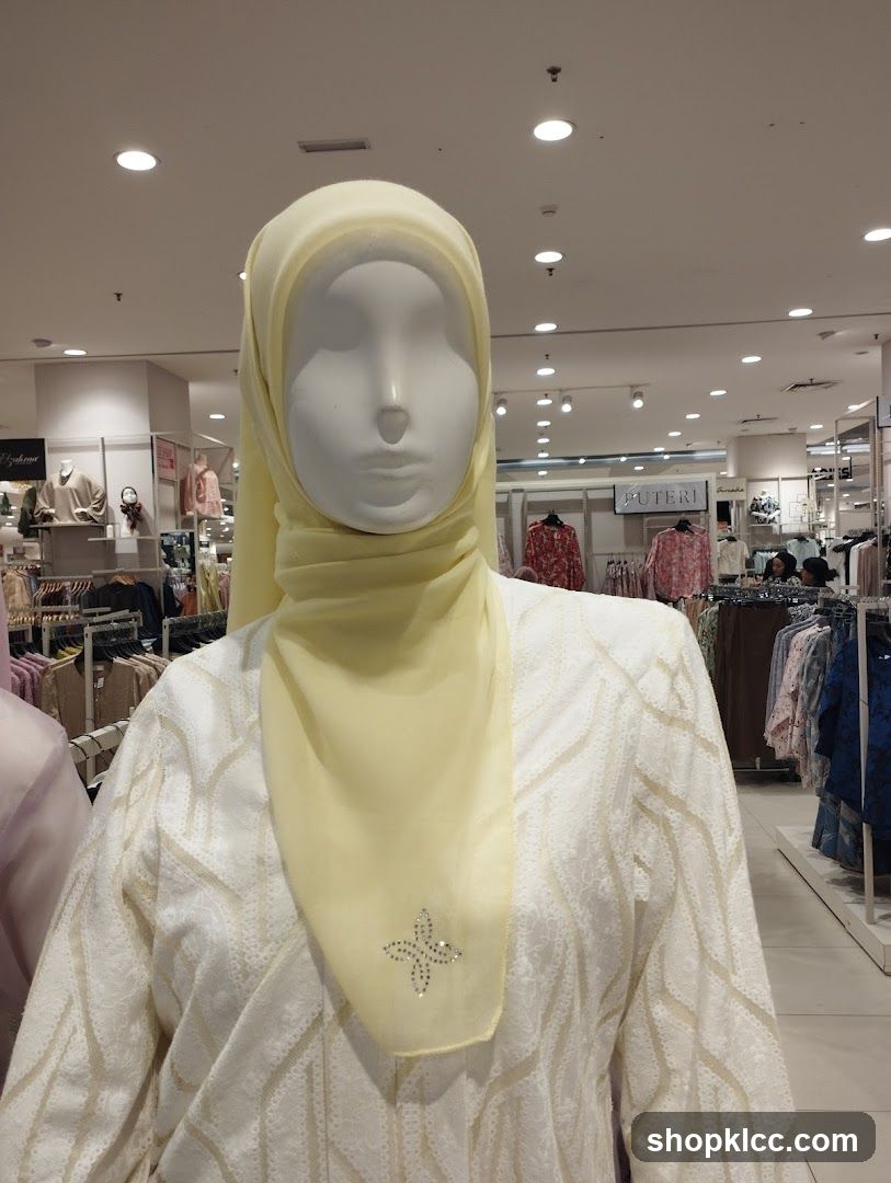 Mannequin wearing a yellow hijab and white patterned abaya