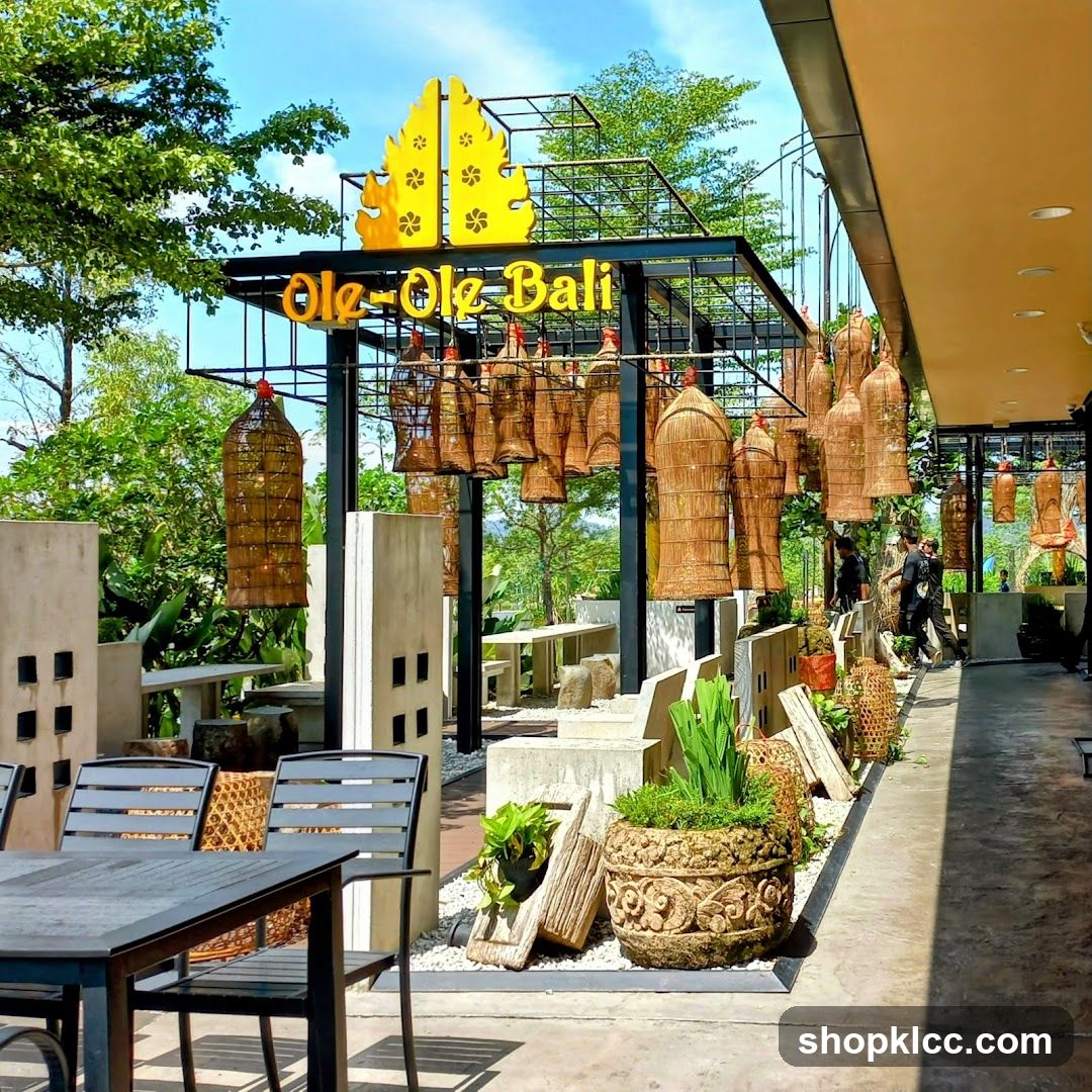 The exterior of a restaurant with a prominent yellow sign that reads "Ole-Ole Bali". The entrance area is decorated with numerous hanging woven baskets and plants. Outdoor seating with tables and chairs is visible. The overall ambiance suggests a tropical or Balinese theme.