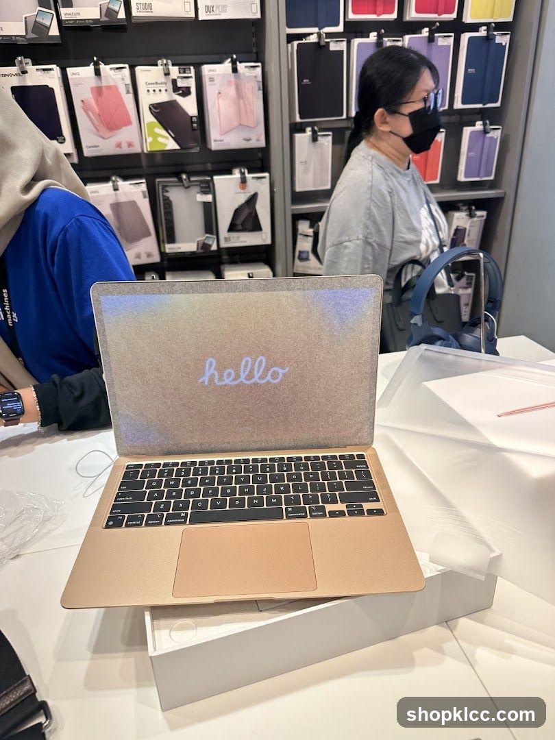 Gold MacBook Air with "hello" on screen