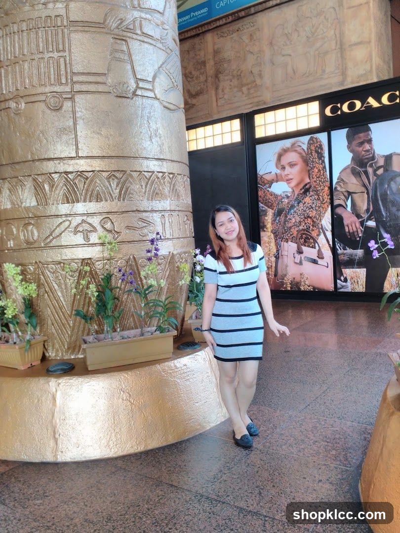 Woman Poses in Front of Coach Store Display