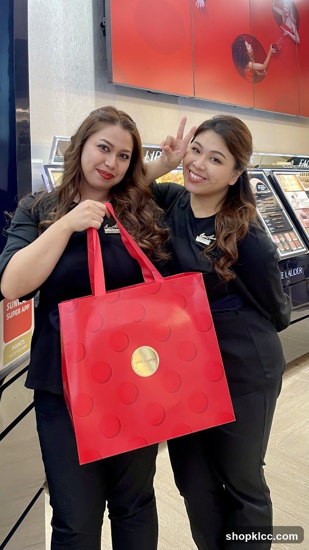 Two women holding a red bag