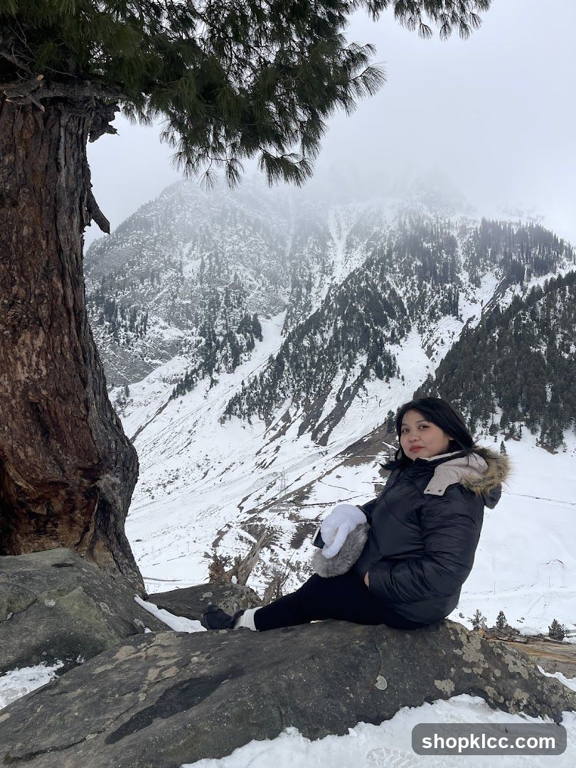 Woman sitting on rocks in snowy mountains