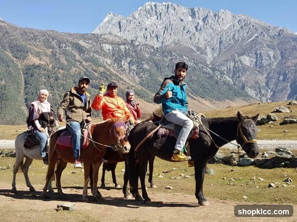 People riding horses in a mountainous landscape