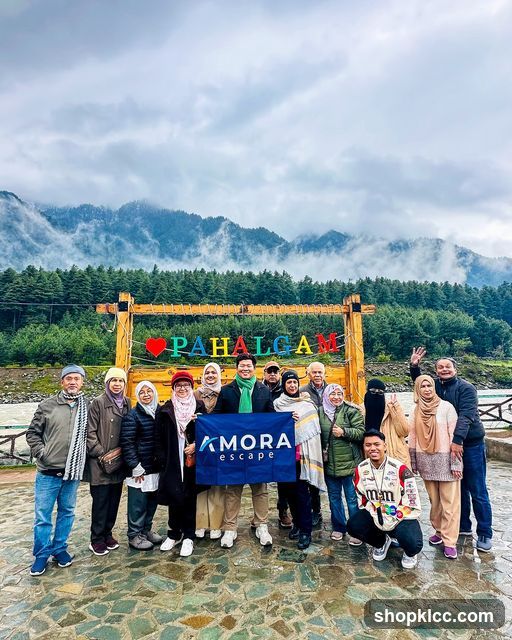 Group posing with a flag in front of a scenic backdrop