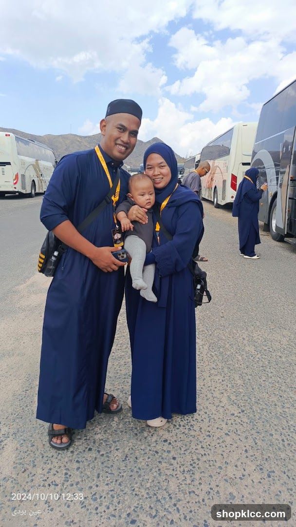 Family posing with buses in the background