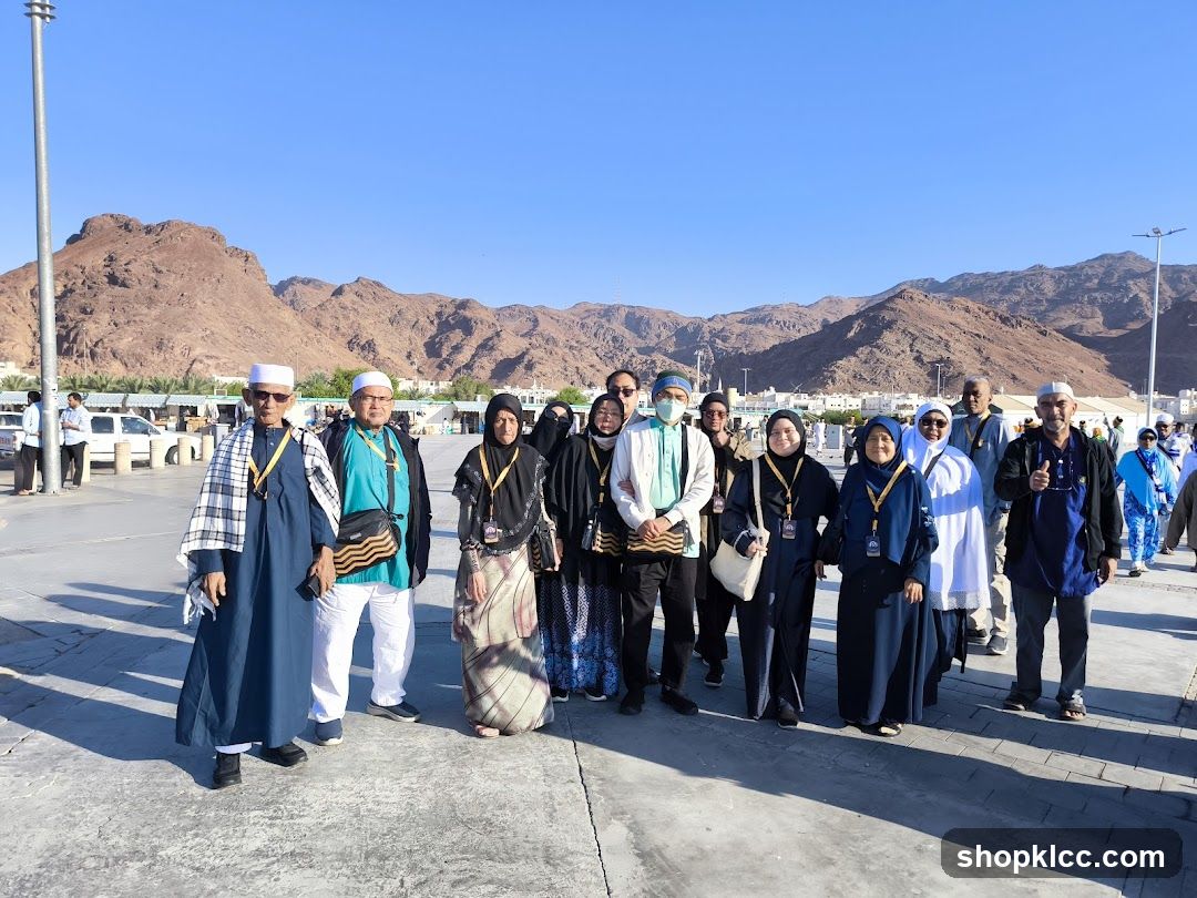 Group of people in traditional attire with mountains in the background