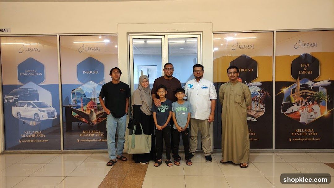 Group posing in front of travel agency advertisements