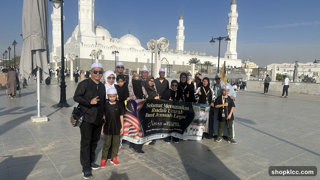 Group Posing with Banner in Front of Mosque
