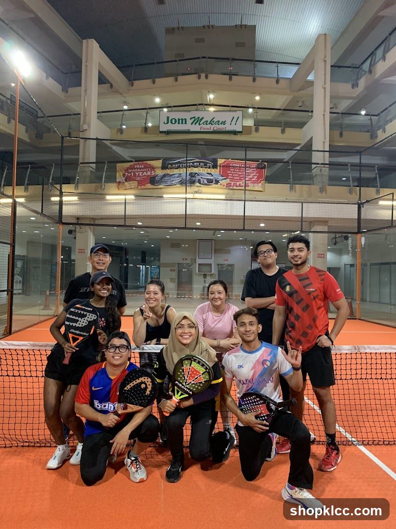 Group of people posing with paddles on a court