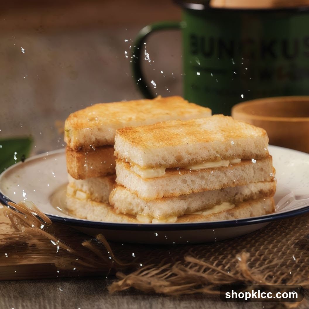 A close-up shot of stacked toast with butter and syrup, served on a white plate with a blue rim. A green mug with the word "BUNGKUS" is visible in the background.