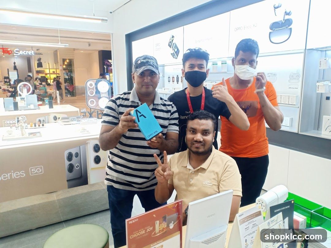 Four men posing in an electronics store