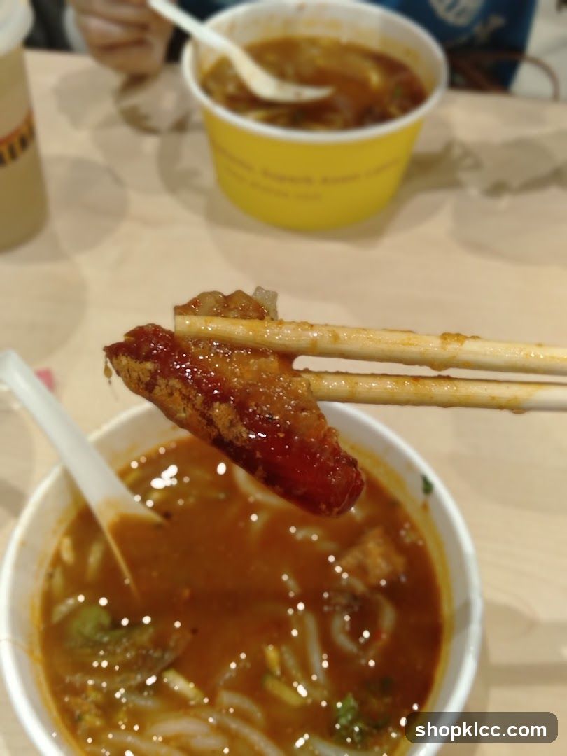 Close-up of a piece of food being held over a bowl of soup