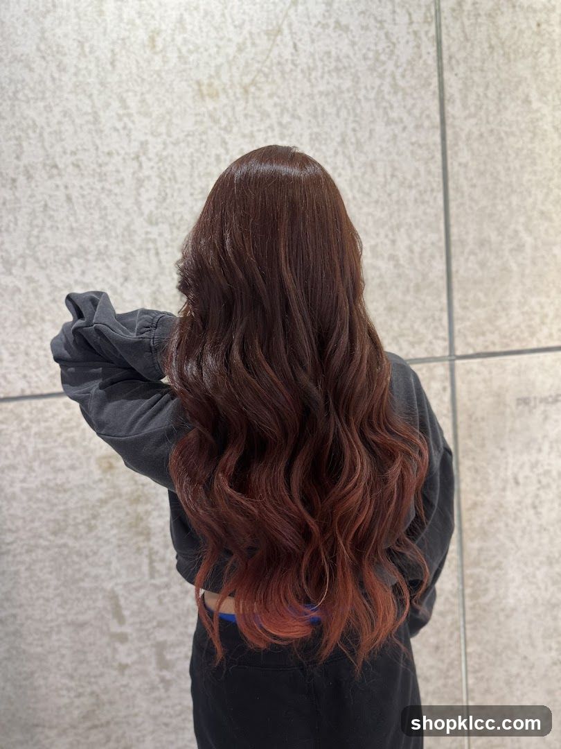 Woman with long, wavy, auburn-tinted hair