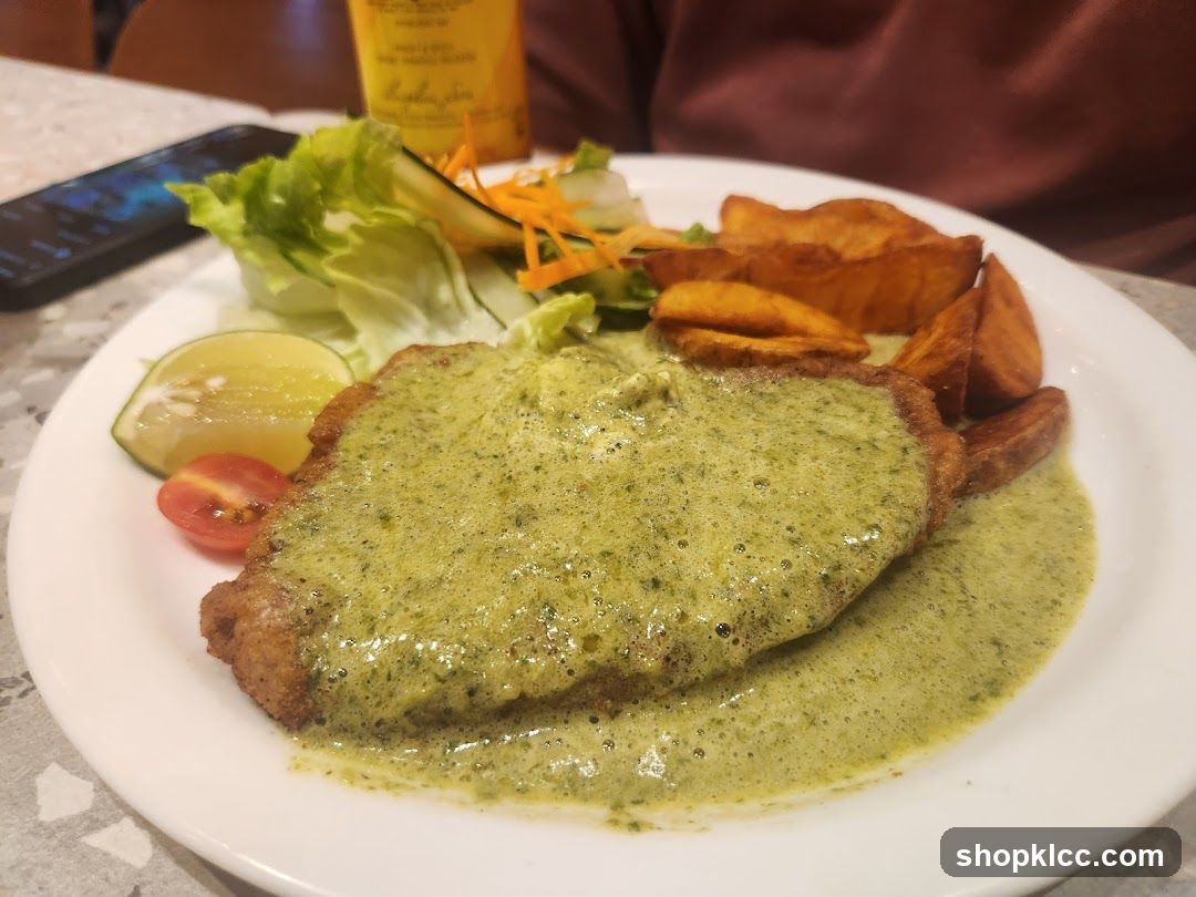 Breaded cutlet with green sauce and potato wedges