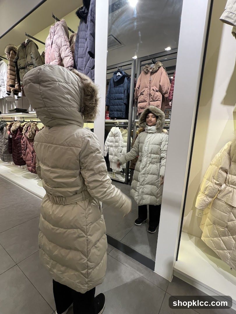 Woman and child trying on winter coats in a store