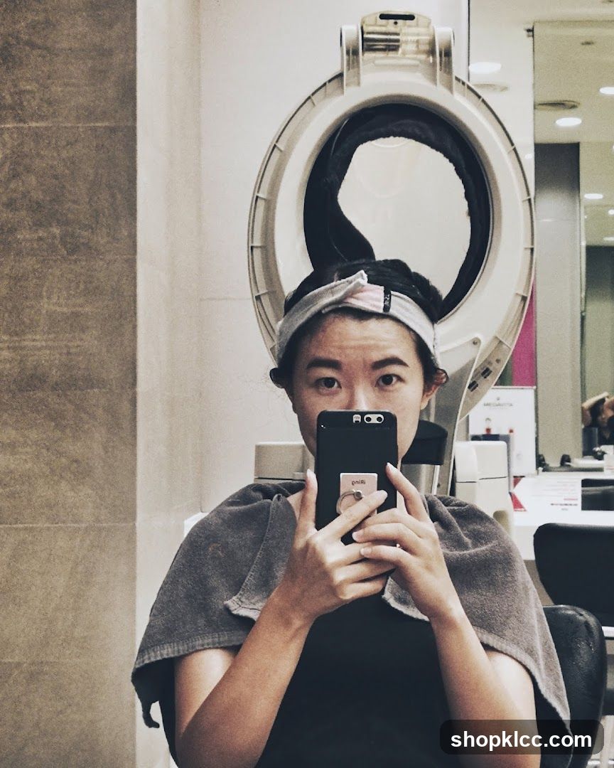 Woman taking a selfie under a hair dryer