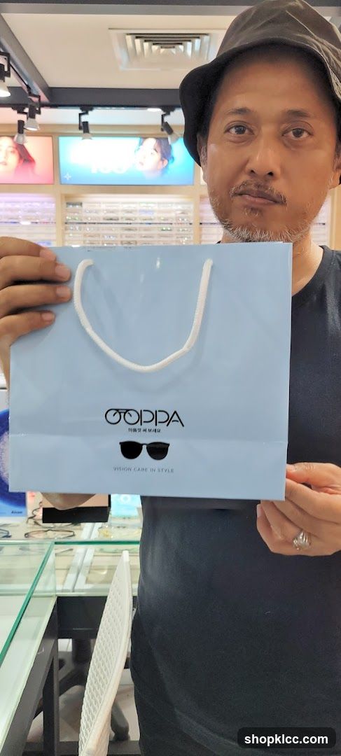 Man holding a shopping bag with glasses logo