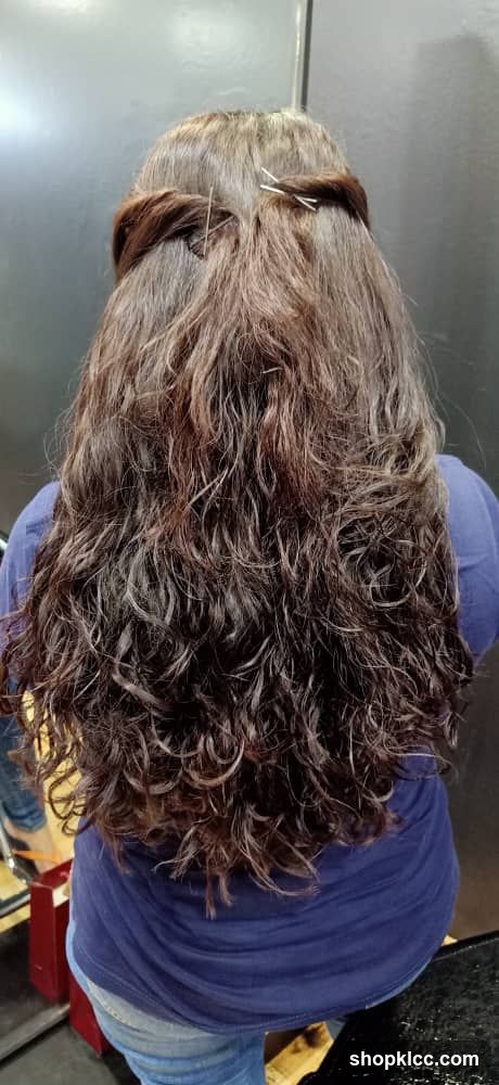 Woman's long, wavy, brown hair styled with a braid and pins