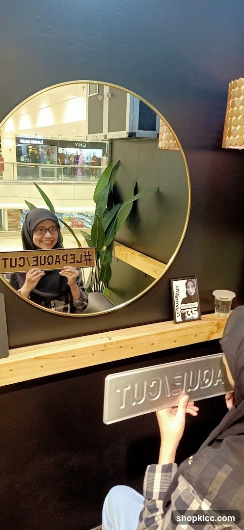 Woman holding a sign in front of a mirror