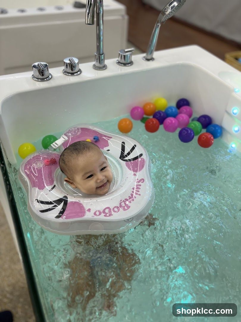 Baby enjoying a bath with colorful balls