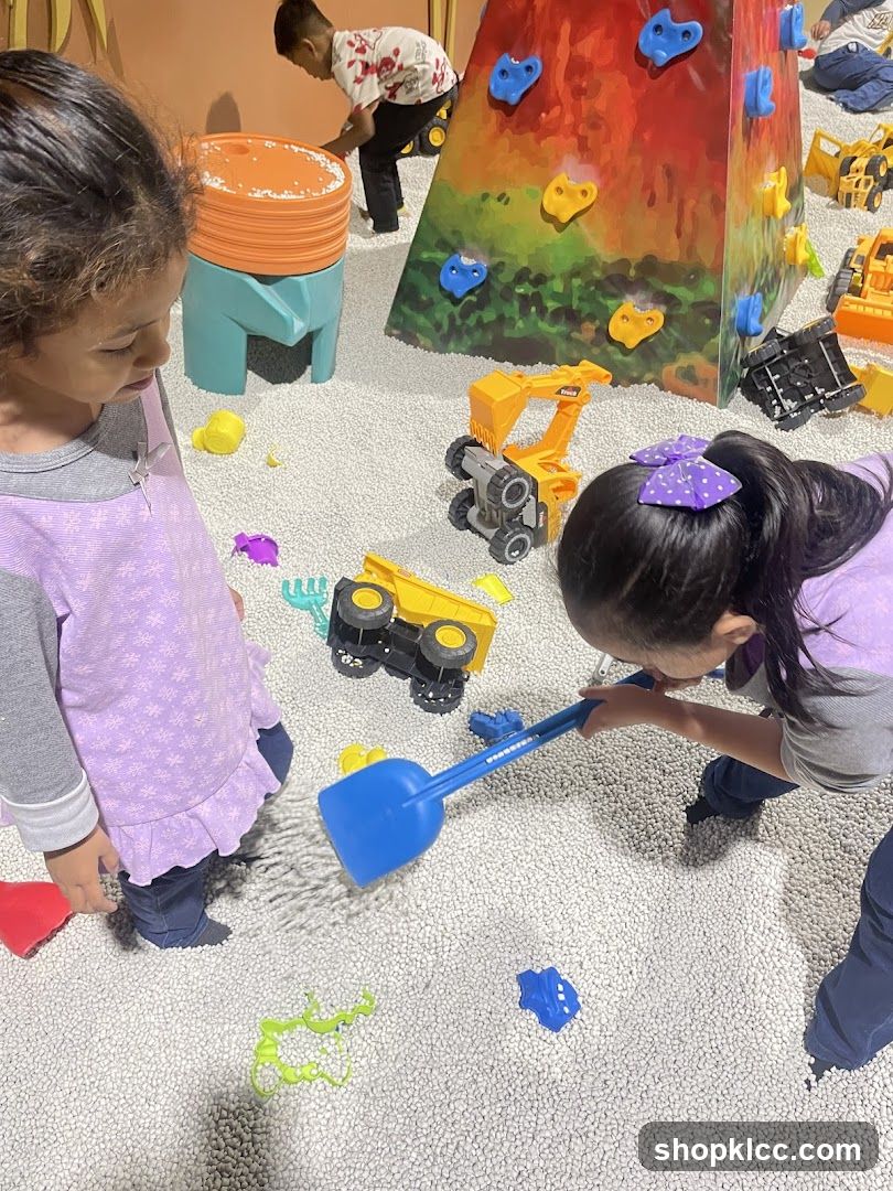 Children Playing in a Ball Pit with Toy Construction Vehicles