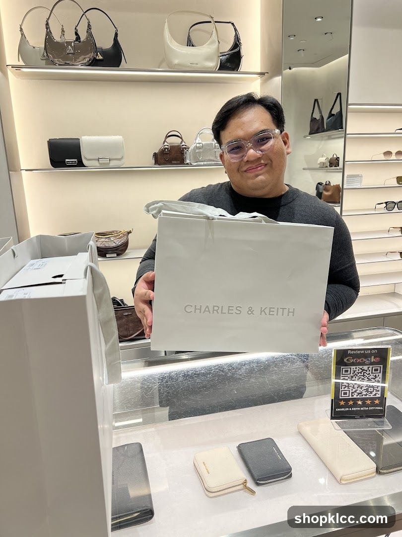 Man holding a Charles & Keith shopping bag