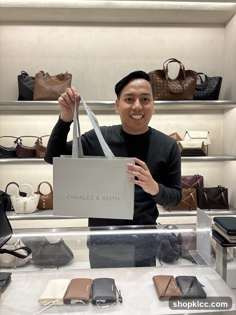 Man holding a Charles & Keith shopping bag