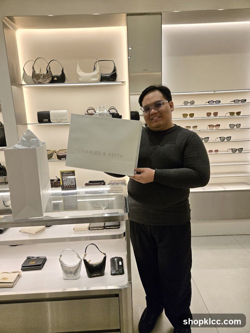 Man holding a Charles & Keith shopping bag
