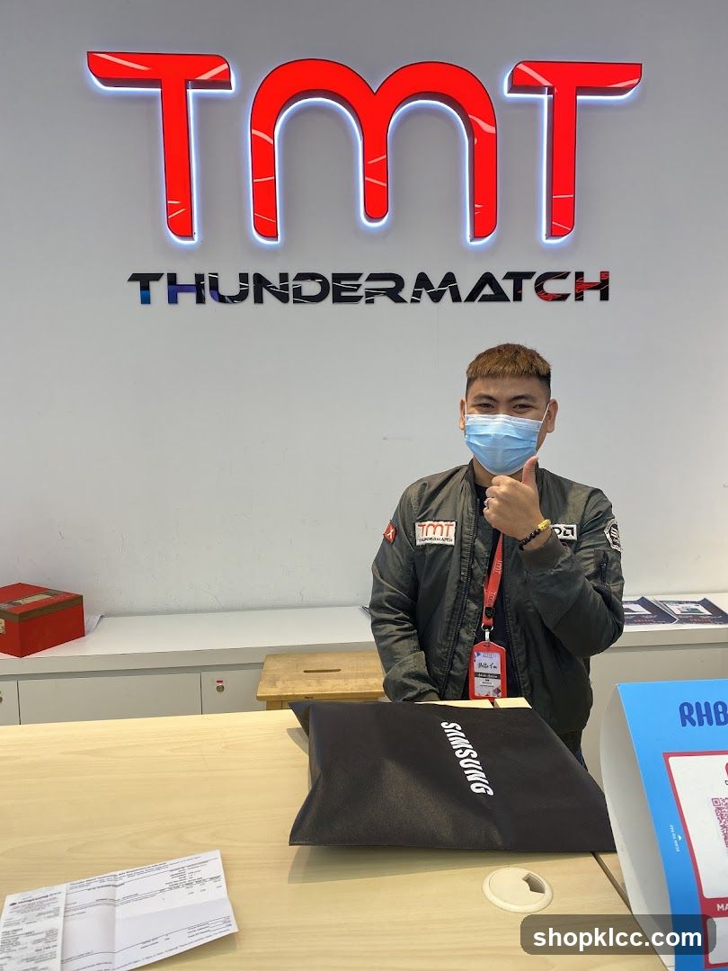 Man giving thumbs up in front of TMT Thunder Match sign
