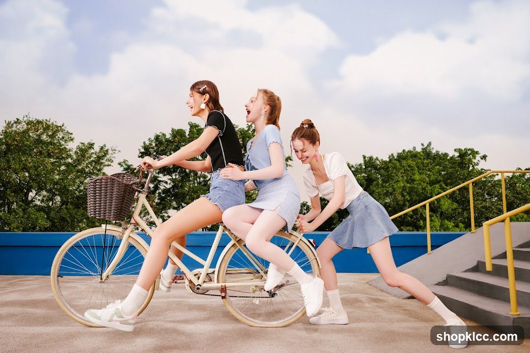 Three young women riding a bicycle