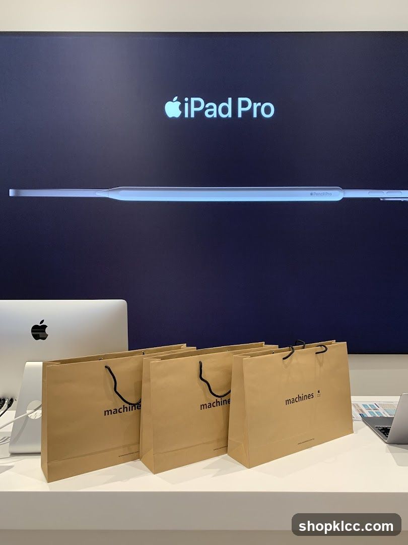 Apple iPad Pro and Pencil Pro display with branded shopping bags