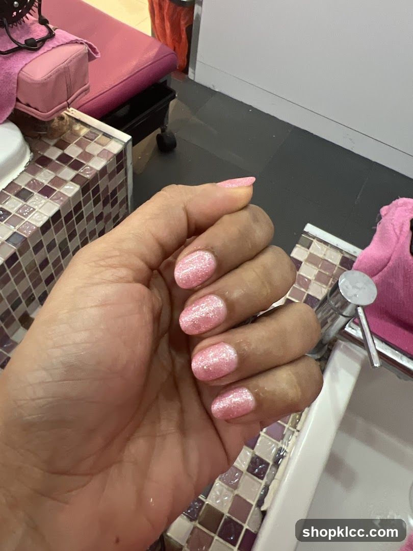 Manicured Hand with Pink Glitter Polish
