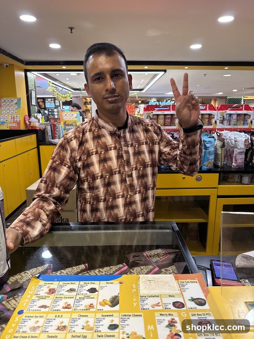 Man behind a counter with a menu