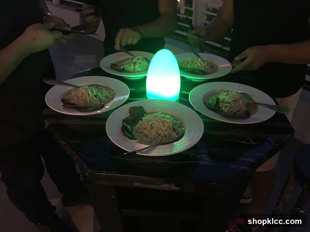 People gathered around a table with bowls of noodles