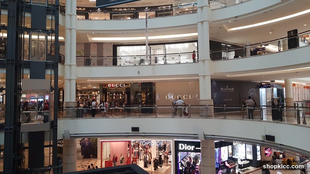 Multi-level shopping mall interior with various stores