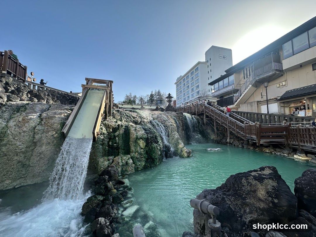Onsen Hot Spring Scene with Waterfall and Buildings
