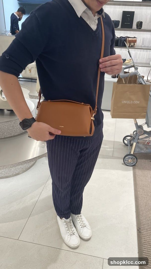 Person holding a brown handbag