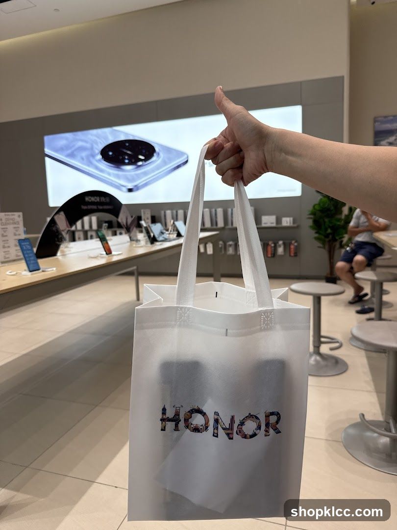 Person holding a shopping bag with the HONOR logo